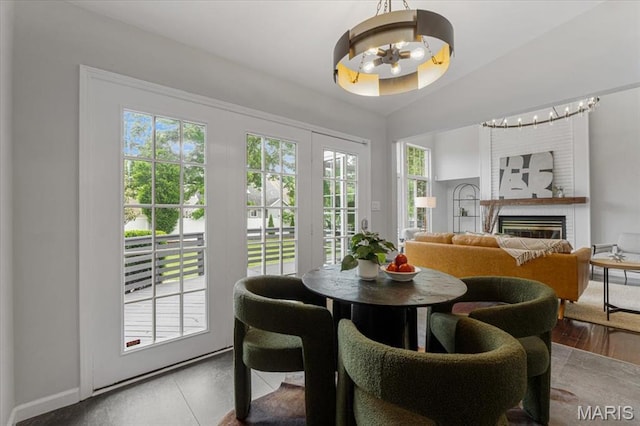938 Blase Ave, Saint Louis, MO 63131 - dining area with a chandelier, a glass covered fireplace, and lofted ceiling