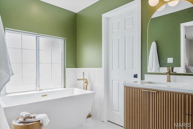 938 Blase Ave, Saint Louis, MO 63131 - bathroom featuring a freestanding bath, vanity, tile patterned floors, wainscoting, and tile walls