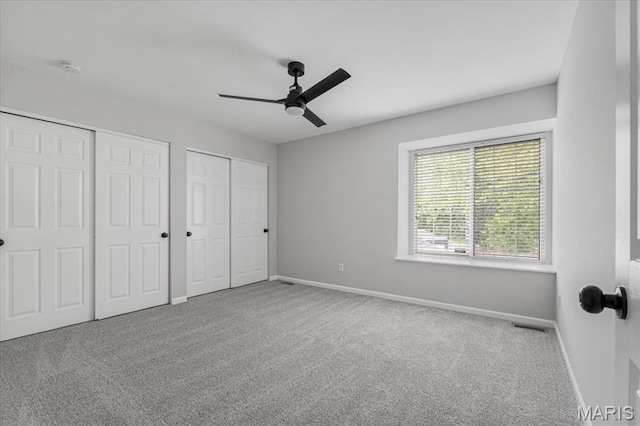 938 Blase Ave, Saint Louis, MO 63131 - unfurnished bedroom featuring multiple closets, carpet flooring, and a ceiling fan