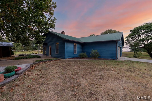 1369 County Highway 408, Benton, MO 63736 - view of home's exterior featuring a chimney, a metal roof, a garage, concrete driveway, and a yard