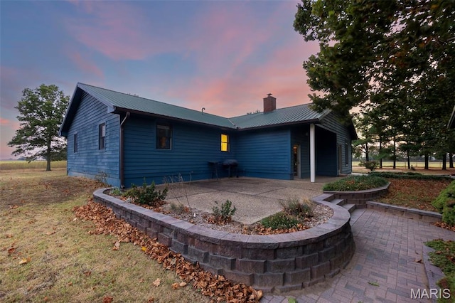 1369 County Highway 408, Benton, MO 63736 - view of front facade with a patio area, a metal roof, and a chimney