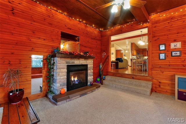 1369 County Highway 408, Benton, MO 63736 - carpeted living area with wood walls, a fireplace, a ceiling fan, and beamed ceiling