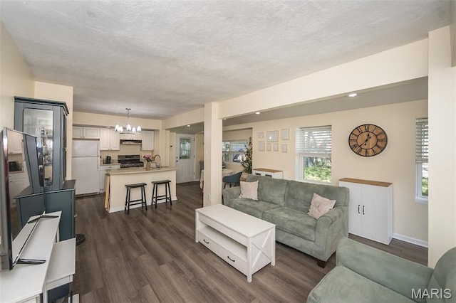 6451 Odell St, Saint Louis, MO 63139 - living room featuring a chandelier, dark wood finished floors, and a textured ceiling