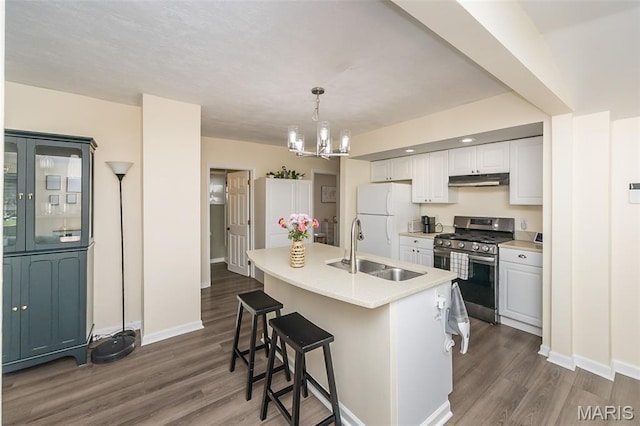 6451 Odell St, Saint Louis, MO 63139 - kitchen with stainless steel range with gas stovetop, freestanding refrigerator, dark wood-type flooring, a chandelier, and a kitchen breakfast bar
