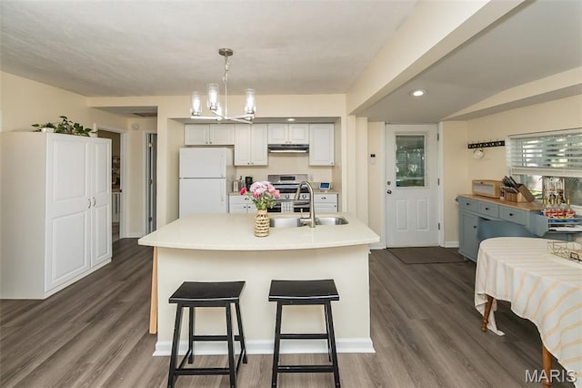 6451 Odell St, Saint Louis, MO 63139 - kitchen featuring freestanding refrigerator, under cabinet range hood, light countertops, dark wood finished floors, and decorative light fixtures