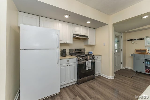 6451 Odell St, Saint Louis, MO 63139 - kitchen with freestanding refrigerator, stainless steel range with gas cooktop, under cabinet range hood, white cabinetry, and dark wood finished floors