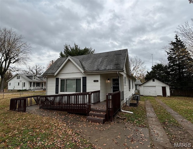9758 Diamond Dr, Riverview, MO 63137 - view of front of home featuring roof with shingles, driveway, a detached garage, an outbuilding, and a deck