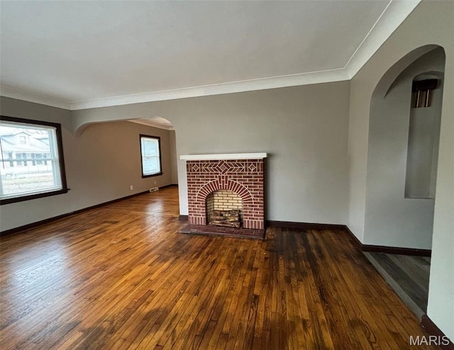 9758 Diamond Dr, Riverview, MO 63137 - unfurnished living room featuring hardwood / wood-style flooring, crown molding, a fireplace, and arched walkways