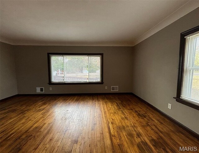 9758 Diamond Dr, Riverview, MO 63137 - empty room featuring plenty of natural light, dark wood-type flooring, and crown molding