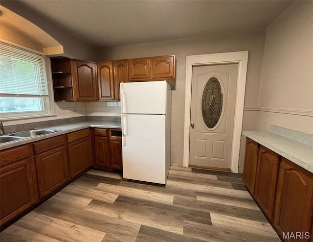9758 Diamond Dr, Riverview, MO 63137 - kitchen featuring freestanding refrigerator, light wood finished floors, open shelves, and brown cabinets