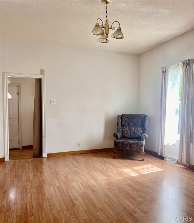 315 E N St, Saint Clair, MO 63077 - unfurnished room with a chandelier, light wood-type flooring, and a textured ceiling