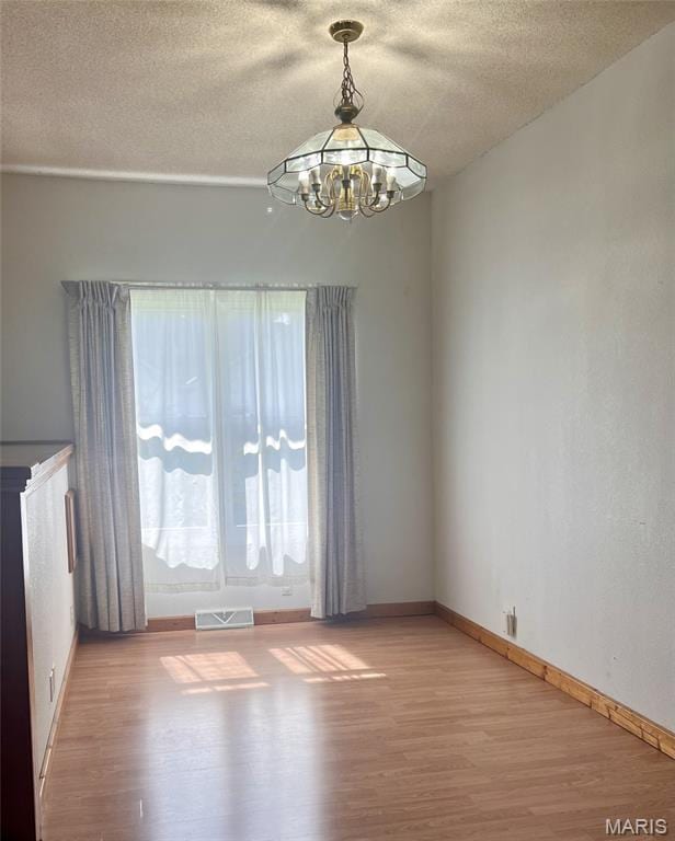 315 E N St, Saint Clair, MO 63077 - spare room with light wood finished floors, a chandelier, and a textured ceiling