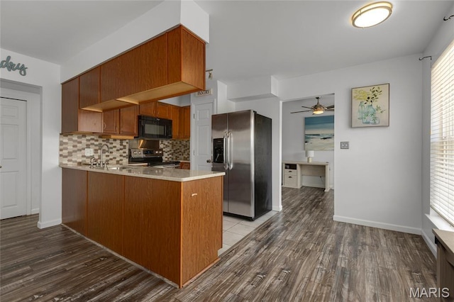 1943 Greenpoint Dr Unit 302, Kirkwood, MO 63122 - kitchen featuring appliances with stainless steel finishes, a peninsula, light countertops, wood finished floors, and ceiling fan