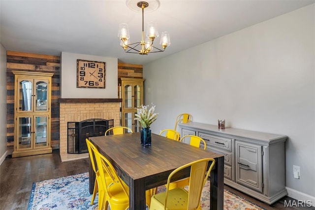 308 Rebecca Dr, Saint Charles, MO 63301 - dining area with a chandelier, a fireplace, dark wood-style flooring, and wooden walls