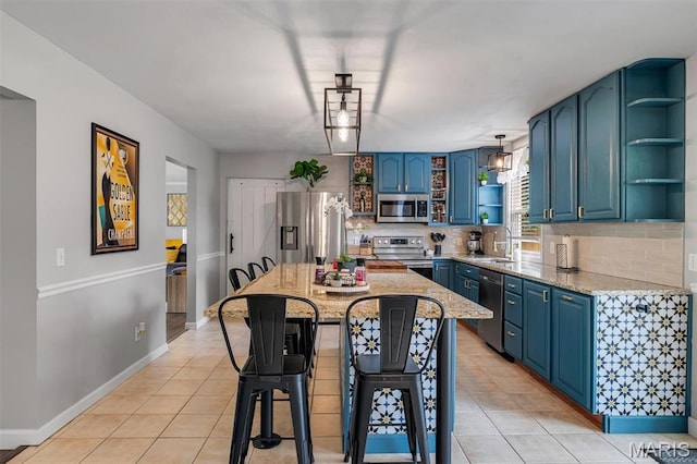 308 Rebecca Dr, Saint Charles, MO 63301 - kitchen with open shelves, appliances with stainless steel finishes, blue cabinetry, and light tile patterned floors