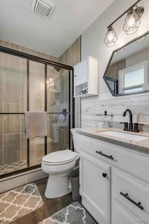 308 Rebecca Dr, Saint Charles, MO 63301 - full bathroom featuring vanity, a shower stall, and wood finished floors
