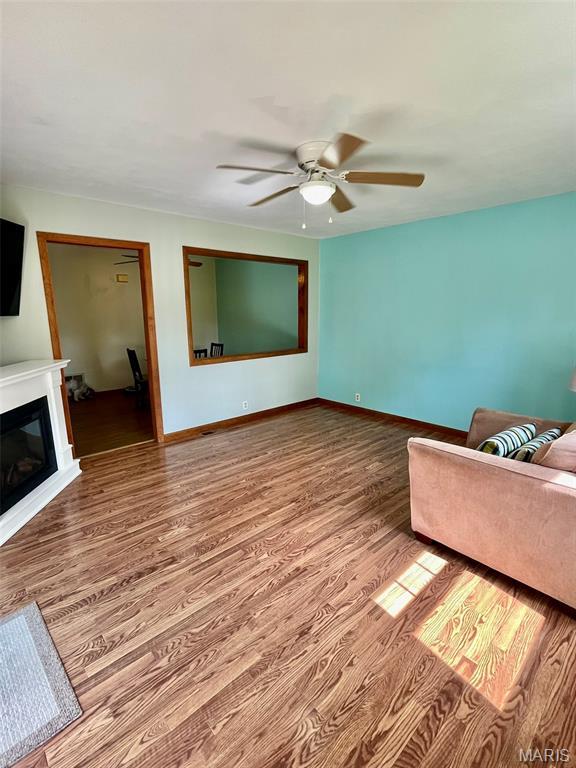 12 Dee, Moro, IL 62067 - unfurnished living room featuring wood finished floors, a ceiling fan, and a glass covered fireplace