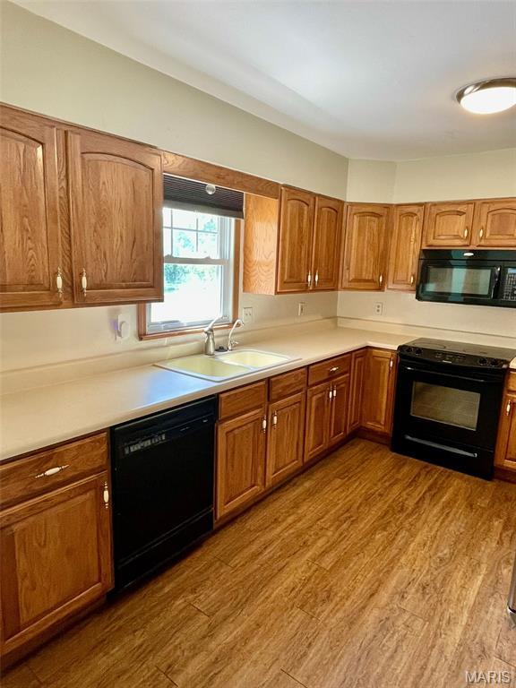 12 Dee, Moro, IL 62067 - kitchen with black appliances, brown cabinetry, wood finished floors, and light countertops
