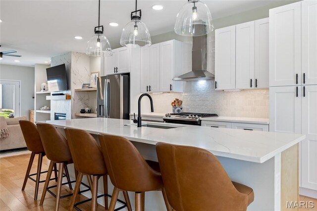 6297 Magnolia Ave, Saint Louis, MO 63139 - kitchen with stainless steel refrigerator with ice dispenser, wall chimney exhaust hood, range, decorative backsplash, and a kitchen island with sink