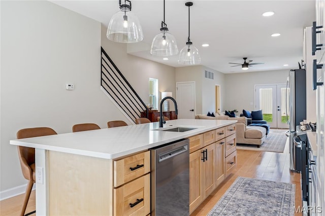 6297 Magnolia Ave, Saint Louis, MO 63139 - kitchen with light brown cabinets, stainless steel dishwasher, a breakfast bar, open floor plan, and recessed lighting