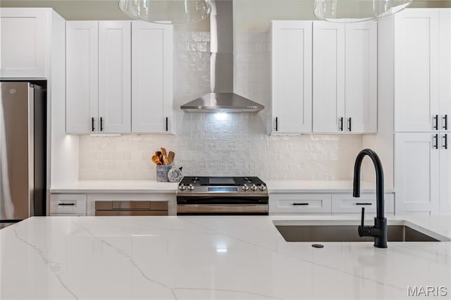 6297 Magnolia Ave, Saint Louis, MO 63139 - kitchen featuring stainless steel appliances, wall chimney exhaust hood, decorative light fixtures, and white cabinetry