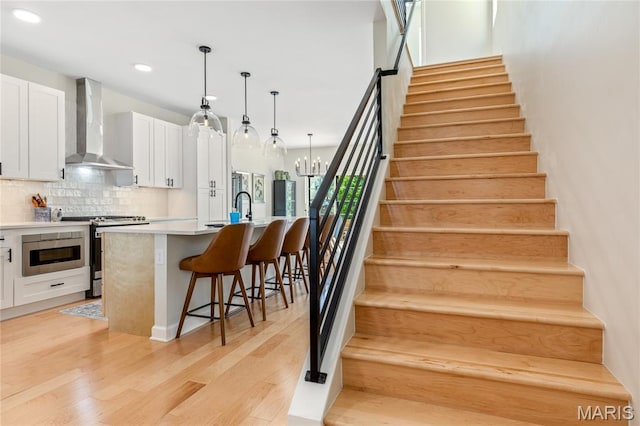 6297 Magnolia Ave, Saint Louis, MO 63139 - stairs featuring wood finished floors, recessed lighting, and a chandelier