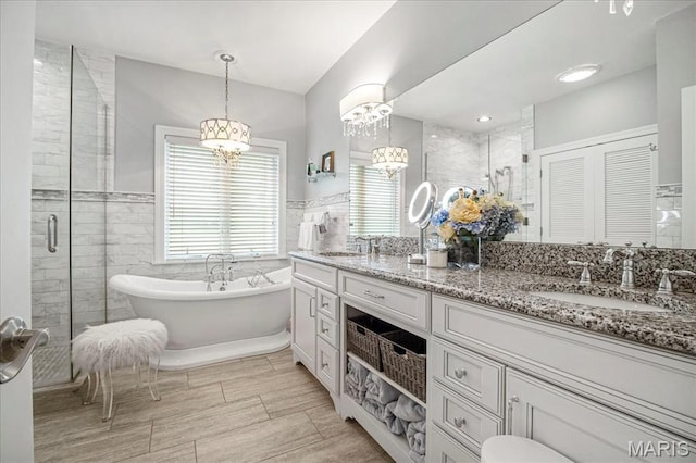 2175 Oberhelman Rd, Foristell, MO 63348 - full bathroom with a chandelier, tile walls, double vanity, a stall shower, and a freestanding tub
