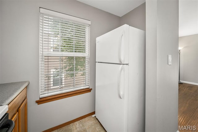 1141 Arbor Creek Dr Unit 2C, Saint Louis, MO 63122 - kitchen featuring freestanding refrigerator, brown cabinetry, light countertops, and stove