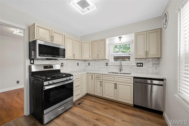 841 N Geyer Rd, Kirkwood, MO 63122 - kitchen with appliances with stainless steel finishes, cream cabinetry, decorative backsplash, and wood finished floors