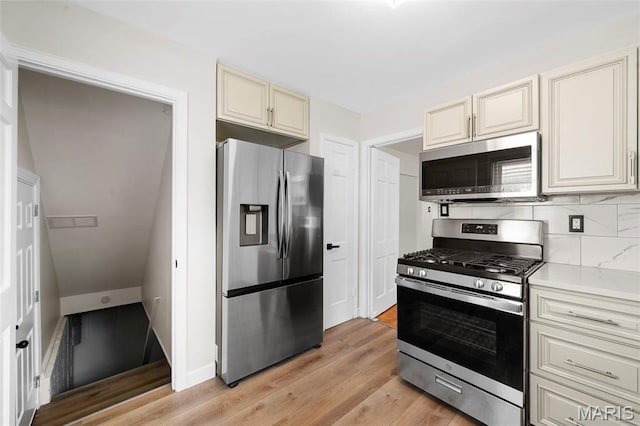 841 N Geyer Rd, Kirkwood, MO 63122 - kitchen featuring appliances with stainless steel finishes, cream cabinets, decorative backsplash, light wood finished floors, and light countertops
