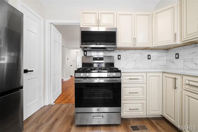 841 N Geyer Rd, Kirkwood, MO 63122 - kitchen featuring stainless steel appliances, light countertops, wood finished floors, and decorative backsplash