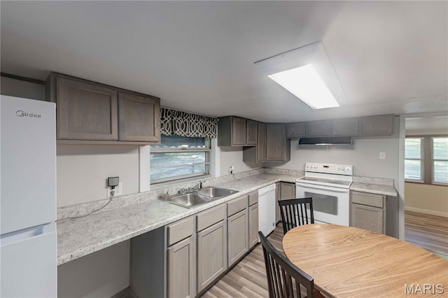 656 Sunset Farms Trl, Union, MO 63084 - kitchen with white appliances, light countertops, light wood finished floors, and under cabinet range hood