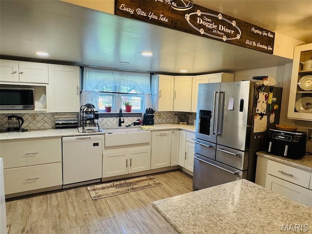 1516 W Main St, Vandalia, IL 62471 - kitchen featuring appliances with stainless steel finishes, white cabinets, tasteful backsplash, light wood-style floors, and recessed lighting