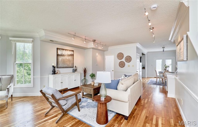 3432 Civic Green Dr, Saint Charles, MO 63301 - living area with rail lighting, light wood-type flooring, ornamental molding, a textured ceiling, and french doors