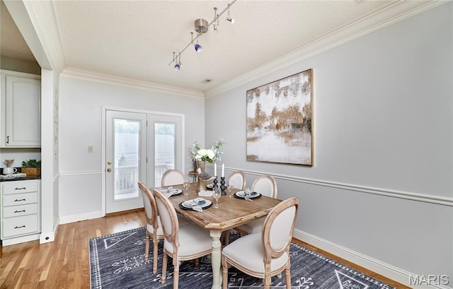 3432 Civic Green Dr, Saint Charles, MO 63301 - dining space featuring light wood finished floors, ornamental molding, track lighting, and a textured ceiling