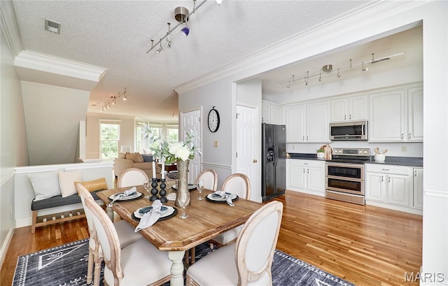 3432 Civic Green Dr, Saint Charles, MO 63301 - dining space with rail lighting, a textured ceiling, crown molding, and light wood-style floors