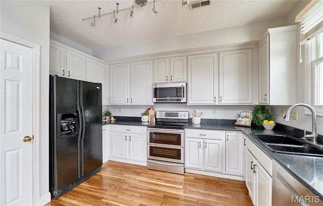 3432 Civic Green Dr, Saint Charles, MO 63301 - kitchen with appliances with stainless steel finishes, white cabinets, light wood-type flooring, and a textured ceiling