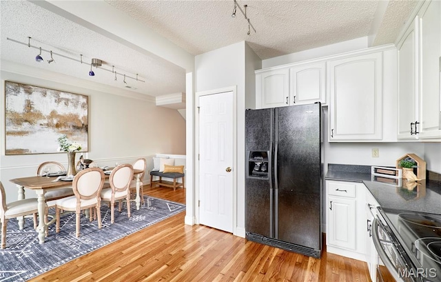 3432 Civic Green Dr, Saint Charles, MO 63301 - kitchen featuring black fridge, track lighting, dark countertops, light wood finished floors, and a textured ceiling