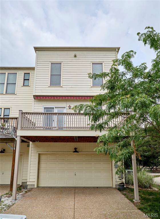 3432 Civic Green Dr, Saint Charles, MO 63301 - back of property featuring a garage, concrete driveway, and a balcony