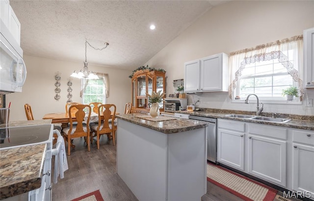 708 Chestnut Dr, Rolla, MO 65401 - kitchen with white appliances, a center island, vaulted ceiling, plenty of natural light, and a textured ceiling