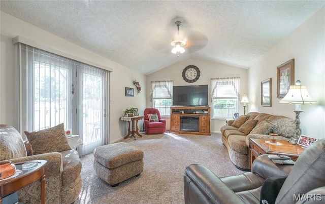 708 Chestnut Dr, Rolla, MO 65401 - living room featuring ceiling fan, carpet, vaulted ceiling, a textured ceiling, and a glass covered fireplace