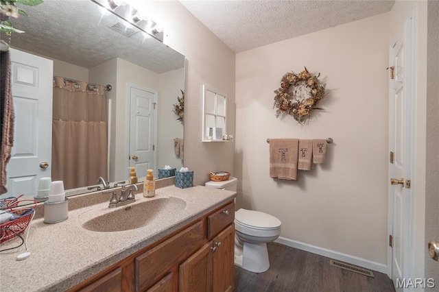 708 Chestnut Dr, Rolla, MO 65401 - bathroom with wood finished floors, vanity, and a textured ceiling