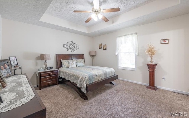 708 Chestnut Dr, Rolla, MO 65401 - carpeted bedroom featuring a tray ceiling, a textured ceiling, and a ceiling fan