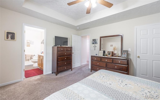 708 Chestnut Dr, Rolla, MO 65401 - carpeted bedroom featuring a raised ceiling, a textured ceiling, ensuite bathroom, and a ceiling fan