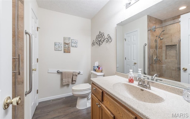708 Chestnut Dr, Rolla, MO 65401 - bathroom featuring vanity, wood finished floors, a textured ceiling, and a tile shower