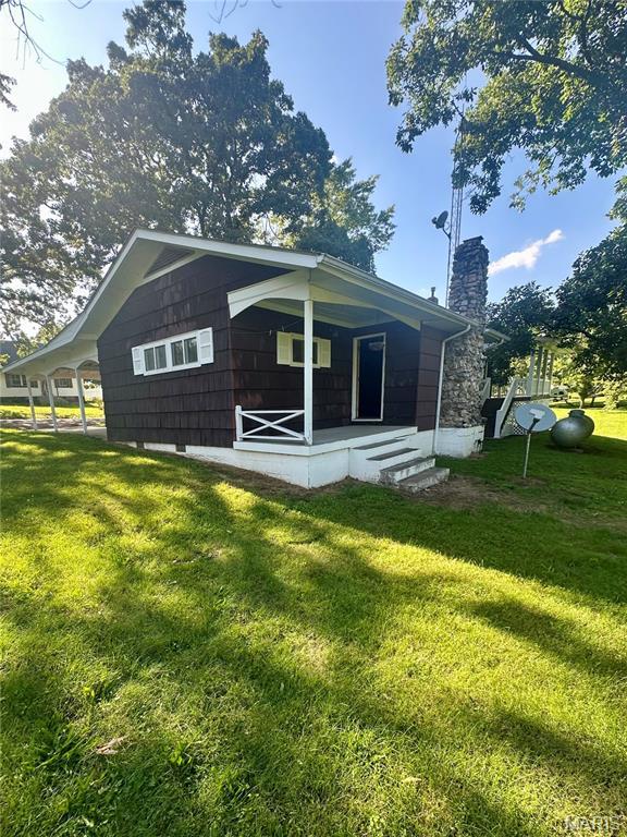 701 Alvarado, Belle, MO 65013 - back of house featuring a yard, a chimney, and a porch