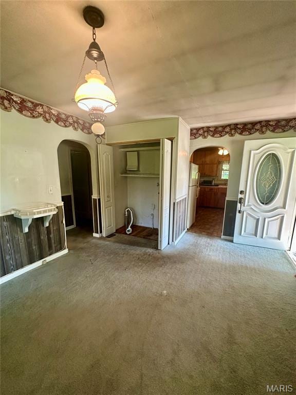 701 Alvarado, Belle, MO 65013 - unfurnished living room with arched walkways and carpet flooring