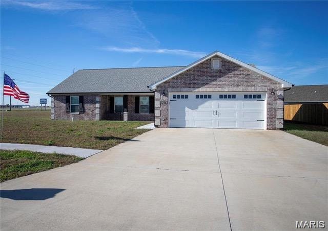 1205 Yosemite, Sikeston, MO 63801 - ranch-style home featuring a garage, brick siding, driveway, and a front lawn