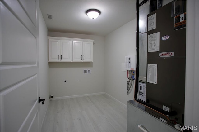 1205 Yosemite, Sikeston, MO 63801 - laundry area featuring heating unit, electric dryer hookup, cabinet space, light wood-type flooring, and hookup for a washing machine