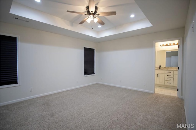 1205 Yosemite, Sikeston, MO 63801 - unfurnished bedroom with light carpet, recessed lighting, a tray ceiling, ensuite bath, and a ceiling fan